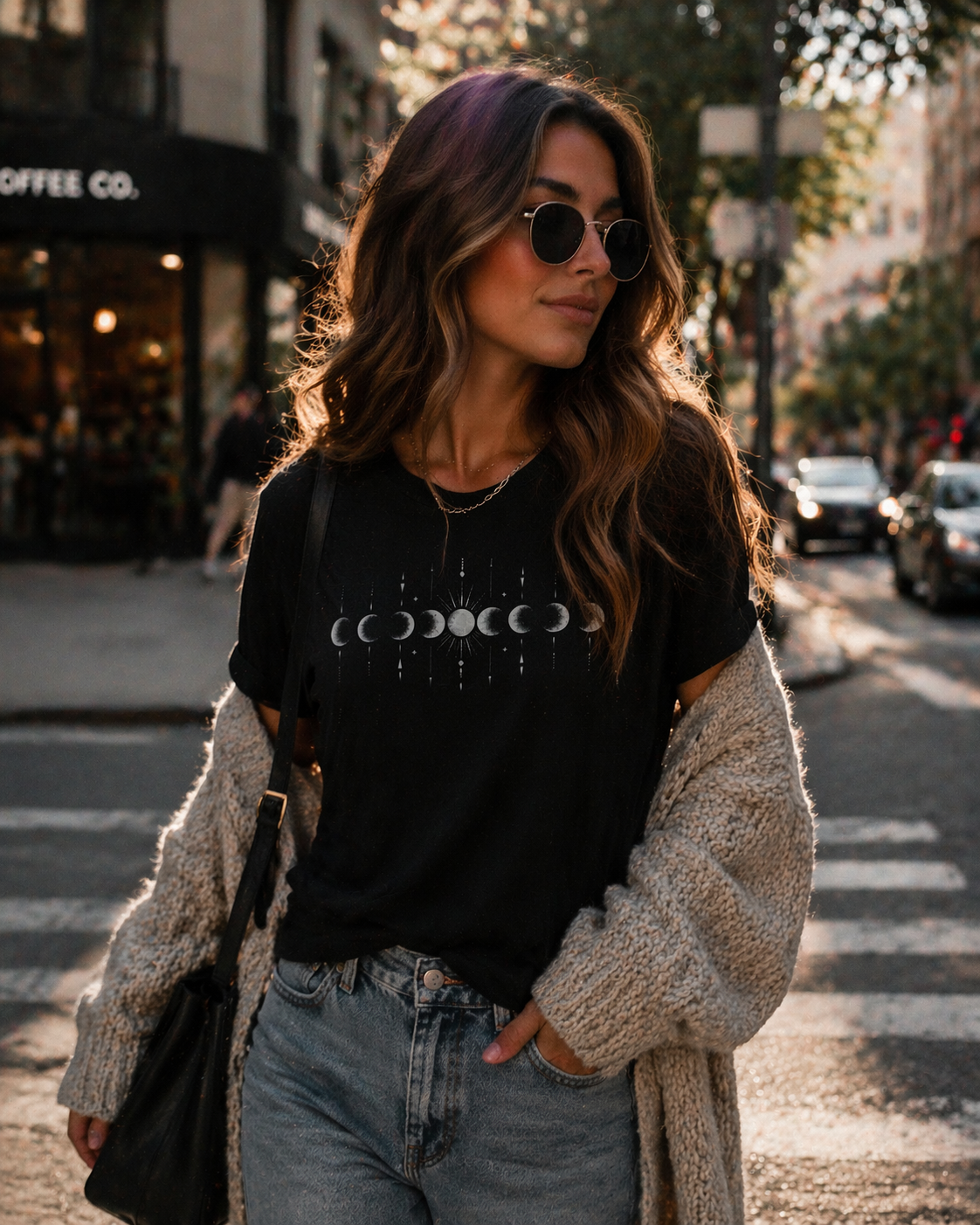 Woman walking on a city street wearing a black t-shirt with a graphic design.